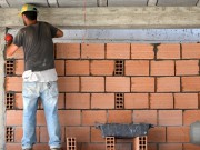 Construction d'un mur par un maçon