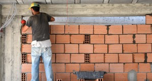 Construction d'un mur par un maçon